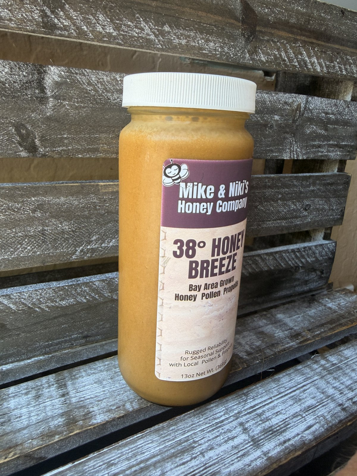 Honey Breeze filled jar, front angle on rustic wood